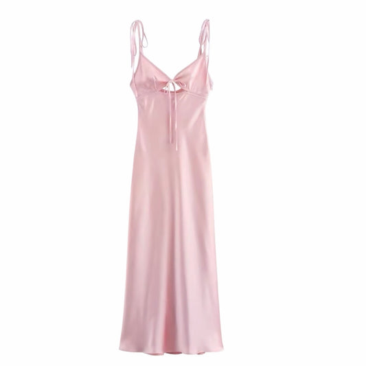 Light pink satin v-neck bodycon maxi dress with hollow-out detail, slim fit silhouette, sleeveless spaghetti straps, chic bow accent, elegant backless design. Feminine coquette-inspired summer sundress for women and teens. Perfect for vacation, brunch, sorority rush, school dances, prom, hoco, homecoming, formal evening, night out, Euro summer parties, and preppy chic style. Ships worldwide to USA, UK, Canada, Australia, New Zealand, Germany, France, Ireland, Denmark, Sweden, Switzerland, Spain, Netherlands