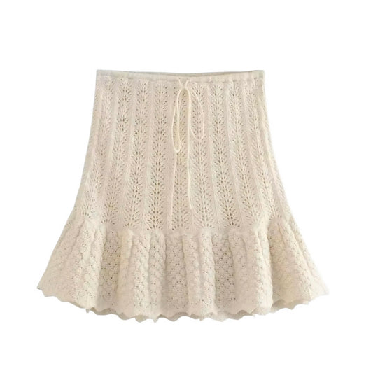 Beige eyelet knit crochet ruffle trim high-rise mini skirt for women, teens, and ladies. Cream white knitted embroidered crochet skirt with floral and geometric patterned details, slim fit A-line sheath silhouette, scalloped hemline, layered ruffle trim, pleated tiered flared style, and flowy feminine design. High-waisted short mini skirt perfect for summer 2025 fashion, holiday vacations, Euro summer, Ibiza style, boho chic, Stockholm streetwear, coastal granddaughter aesthetic, Mediterranean Greece resort