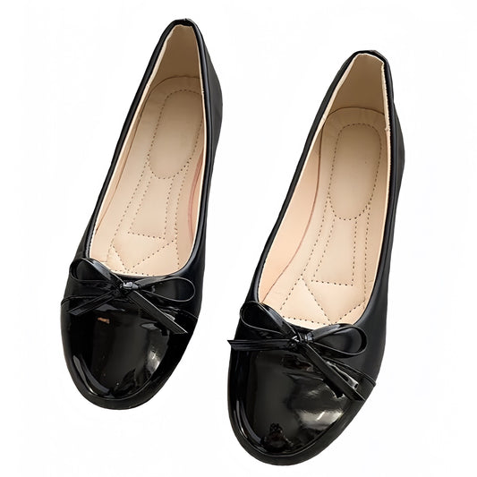 Black faux patent leather ballet flats with bow detail and glossy high-shine finish. Features a smooth vegan-friendly exterior, soft cushioned insole, and low heel for comfort and elegance. Feminine rounded toe silhouette inspired by Parisian chic and old-money minimalist style. Perfect for office, casual, or evening wear. Ships globally to US, UK, Canada, Australia, New Zealand, Europe, and Asia.