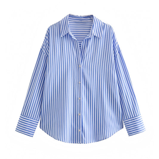 Blue and white striped seersucker linen button down shirt featuring a soft, lightweight, and breathable cotton blend fabric. Designed with a relaxed oversized fit, collared v neckline, and long sleeves for an effortless chic silhouette. Ideal for Euro summer, coastal, and resort wear outfits. Perfect for casual, minimalist, and preppy styles. Ships globally and worldwide to the US, UK, Canada, Australia, New Zealand, Europe, Asia, and beyond.

